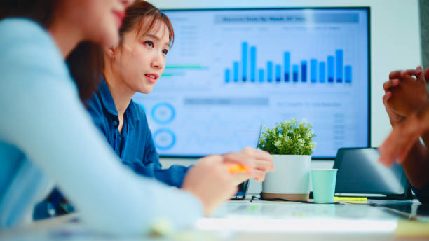 A business team discusses different marketing strategies around a table.